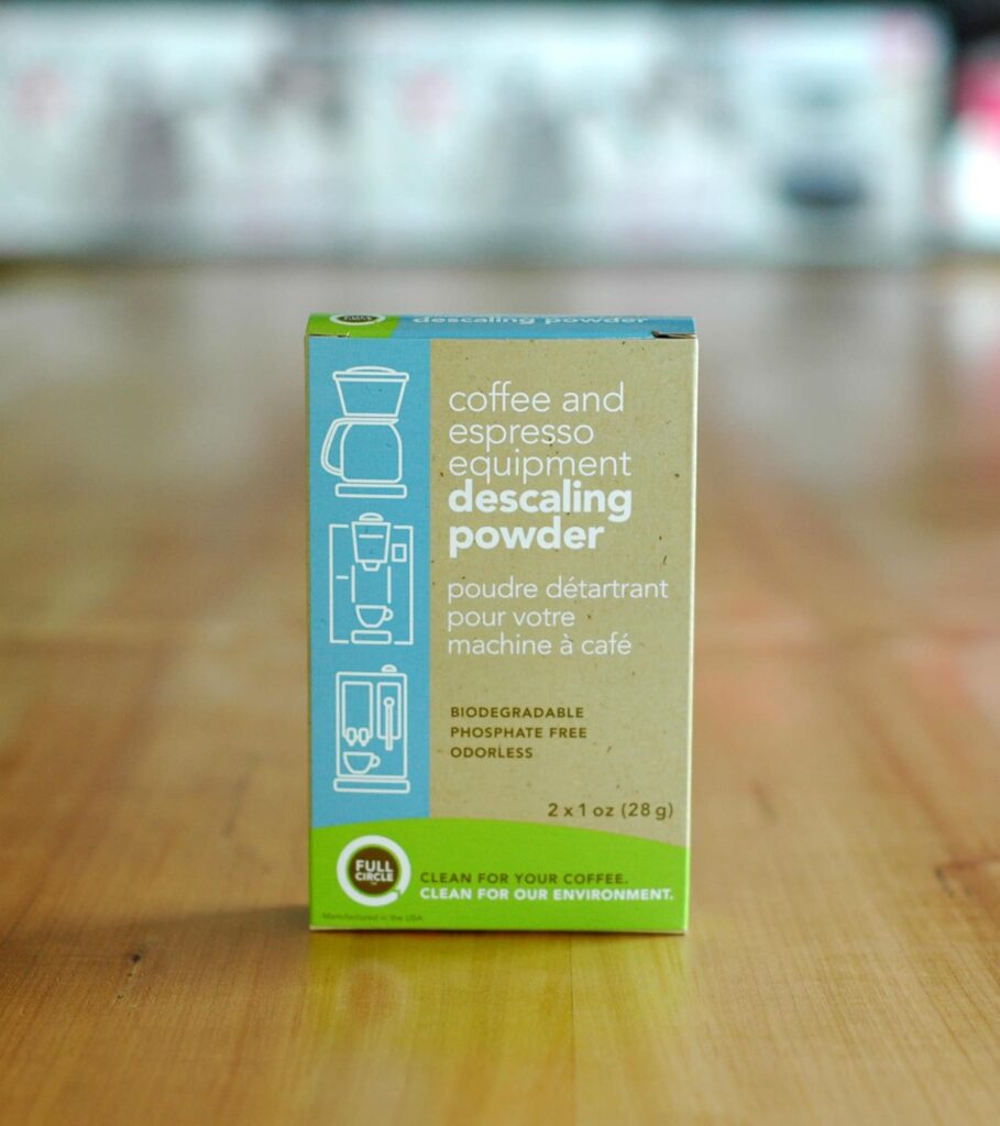 Box of descaling powder on top of a wooden table.