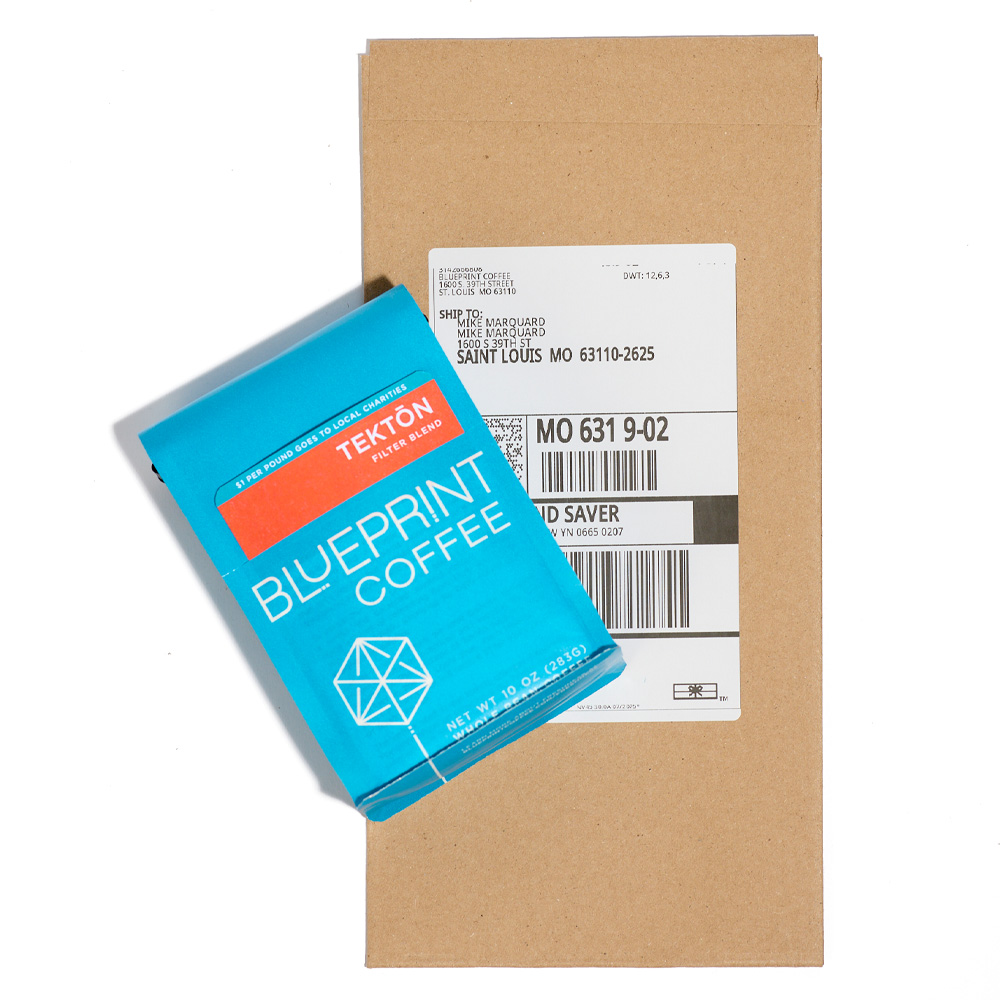 A bag of Tektōn coffee beans on top of a kraft paper mailing envelope.