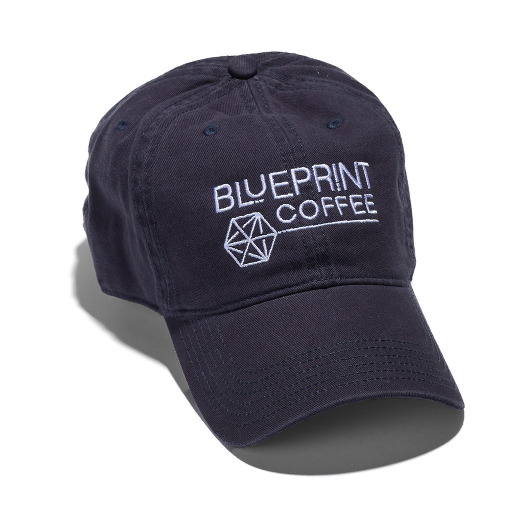 A dark navy blue dad hat embroidered with the Blueprint Coffee logo in white thread across the front